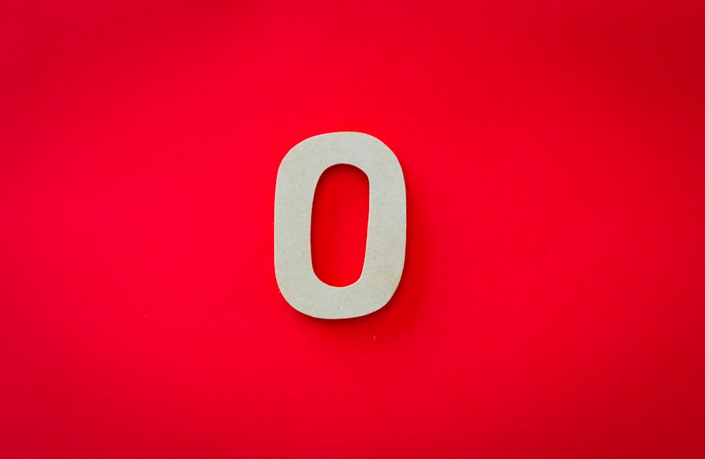 Close-up of a zero cutout on a bright red background with vibrant contrast.