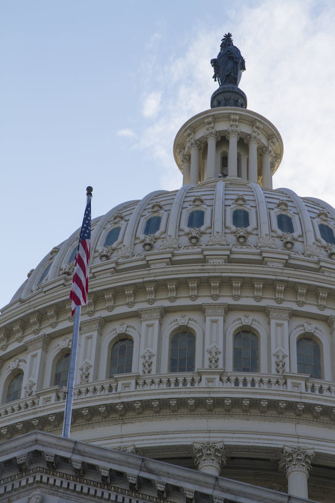 Close-up of the iconic Capitol Dome with American flag in Washington, DC, symbolizing government and history.