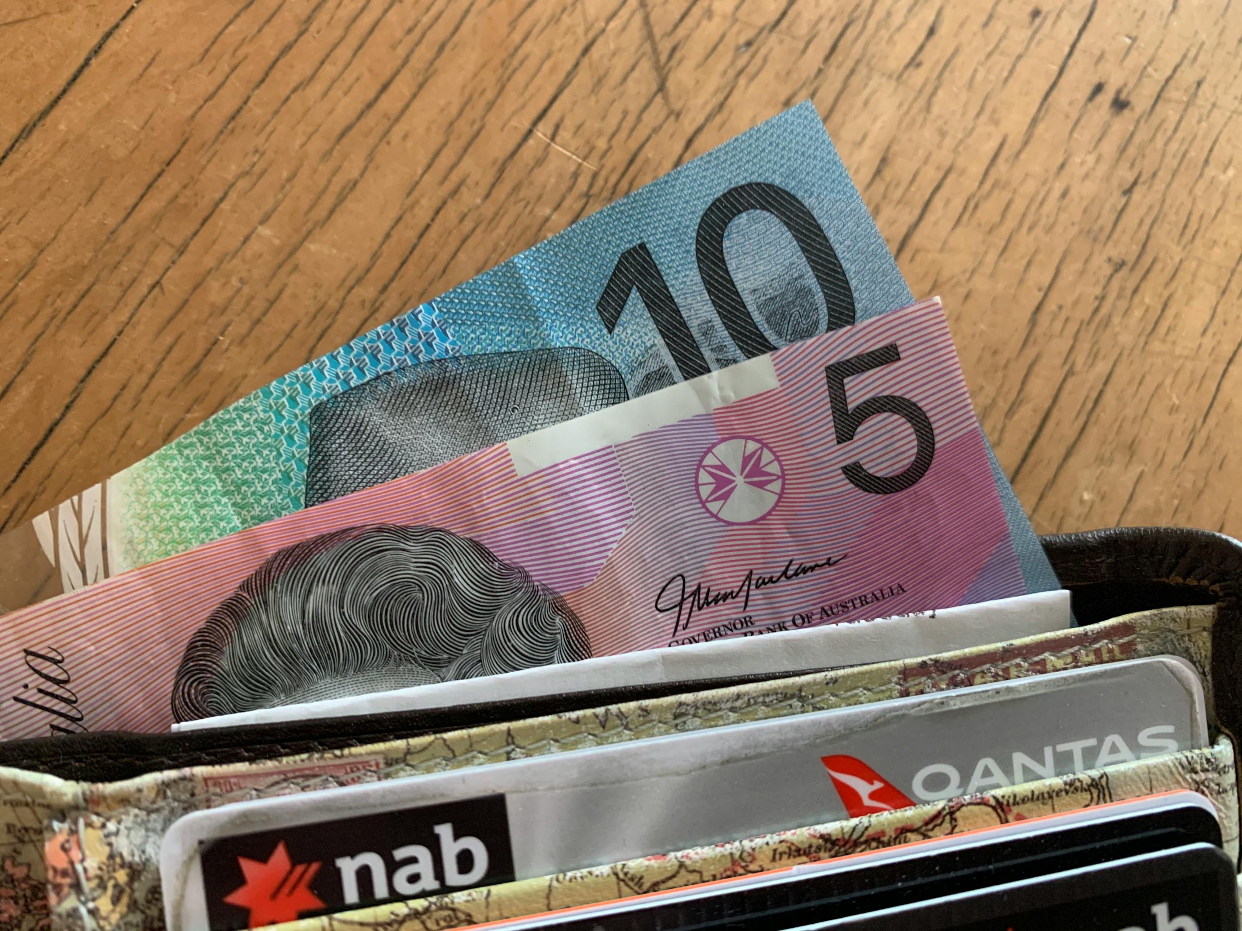 Payday Super 101: Everything You Need to Know Before July 1 1 Close-up of Australian dollar bills and credit cards in a wallet on a wooden surface.