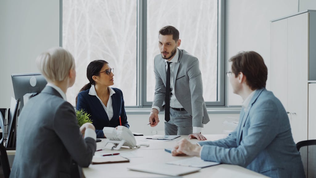 EOFY Checklist: 15 Things Every Aussie Should Do Before 30 June 2026 3 Professionals engaged in a serious business discussion in a bright office environment.